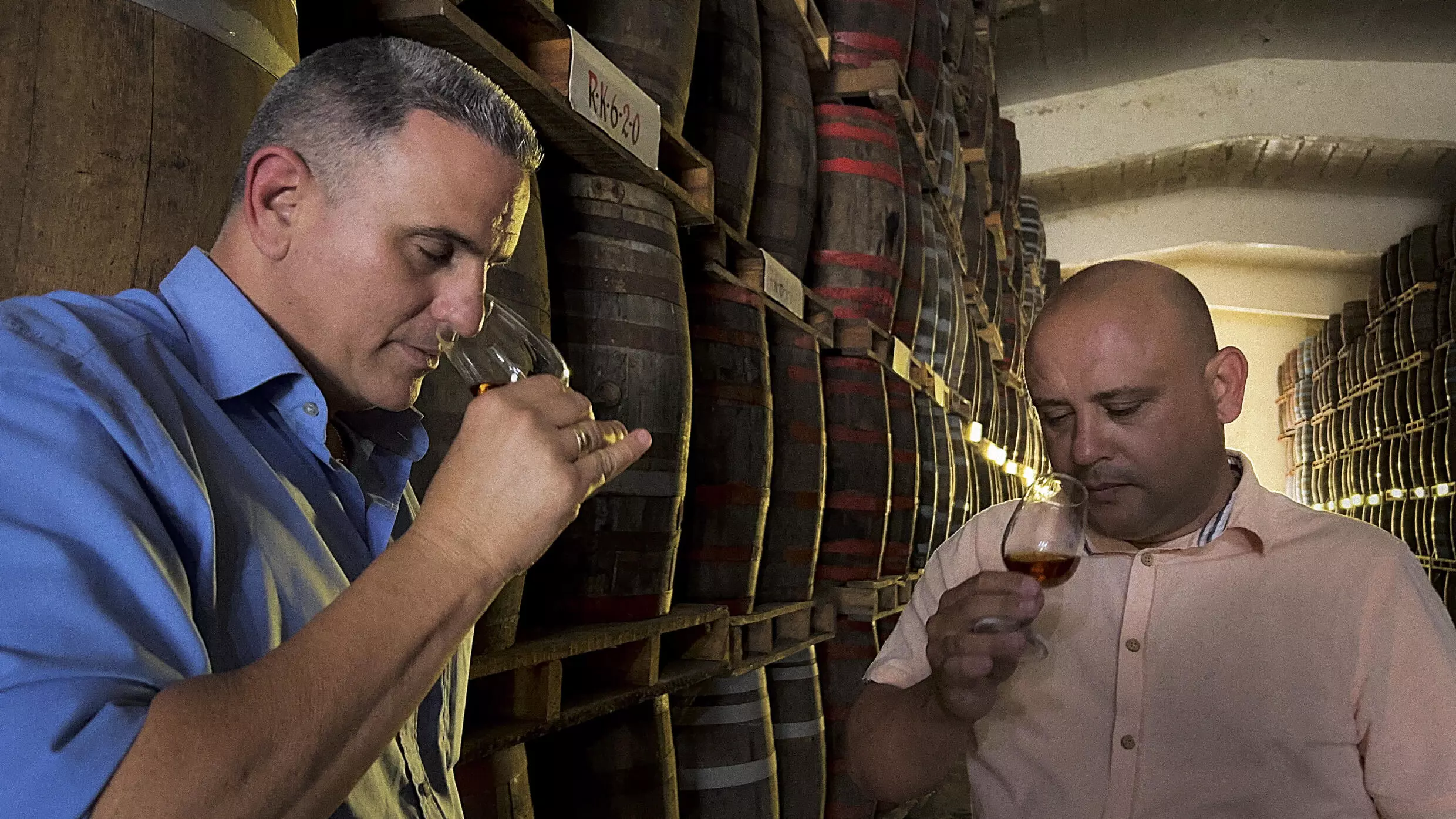 Der kubanische Rum-Meister Cesar Marti (L) hat in der Fabrik in Santo Domingo einen Aspiranten eingestellt. | Bildquelle: FRANCE 24 © ADALBERTO ROQUE / AFP | Bilder sind in der Regel urheberrechtlich geschützt